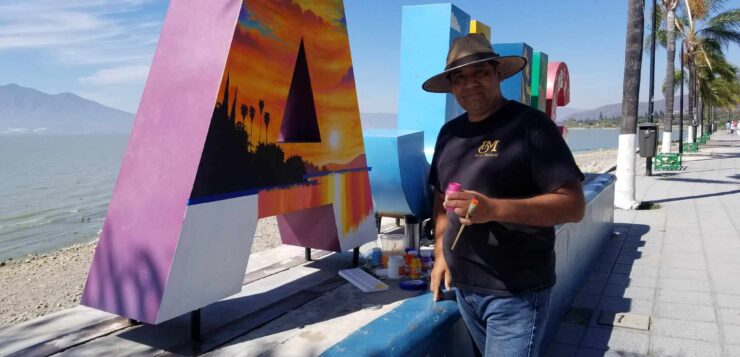 Artist Bruno Mariscal touching up Ajijic letters